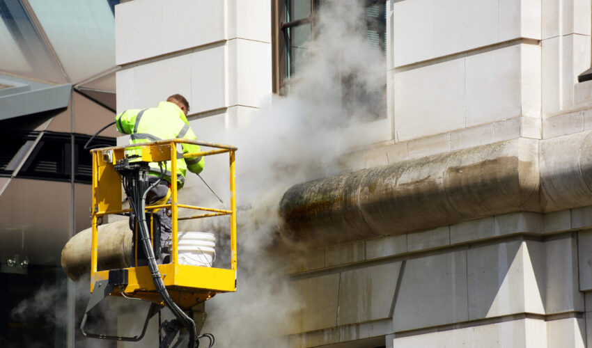 a worker washes the facade of the building